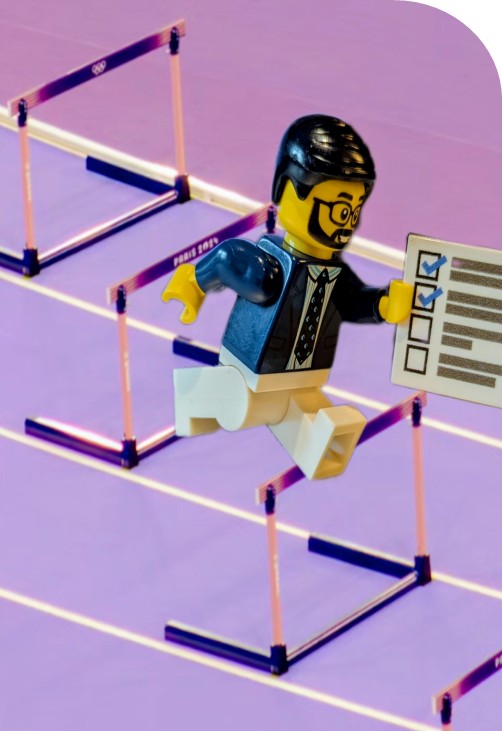 A LEGO minifigure holding a job application whilst jumping over hurdles.